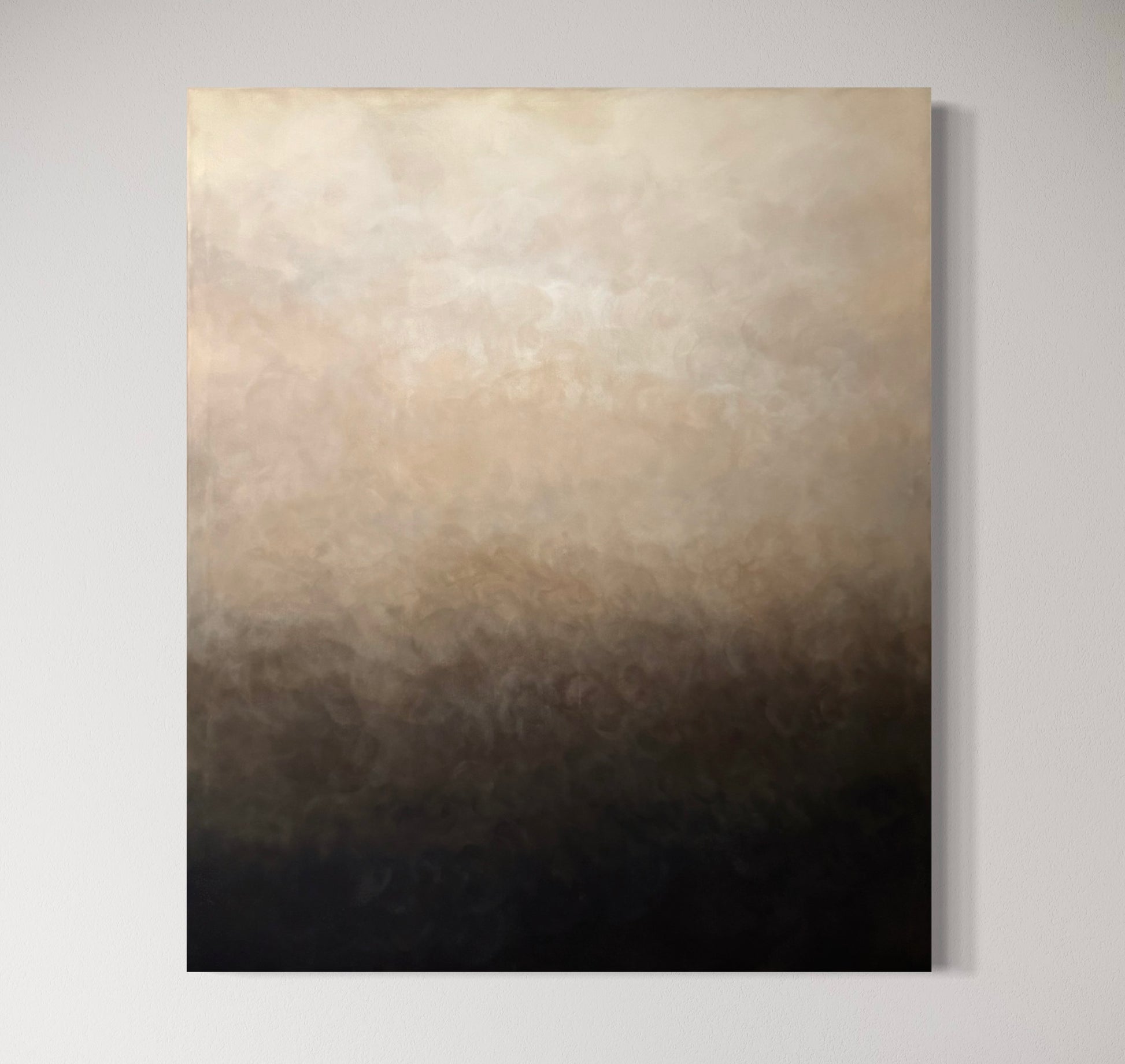 En tavla i vit, beige, brun och svart som hänger på en vit vägg